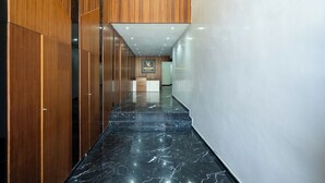 A modern hallway with wooden paneling and a marble floor, leading to a reception area. - Cozy Studio Near Train Stations & Hassan II Mosque (Casablanca)