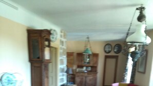 A dining area with a table set for four, a wooden cabinet, and a hanging lamp. - mas Cévenol en Ardèche Animaux Acceptés (rosieres)
