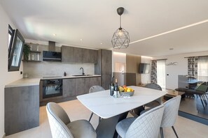Enjoy a spacious living and dining area with a central island breakfast bar, minimalist kitchen, and comfortable seating area.