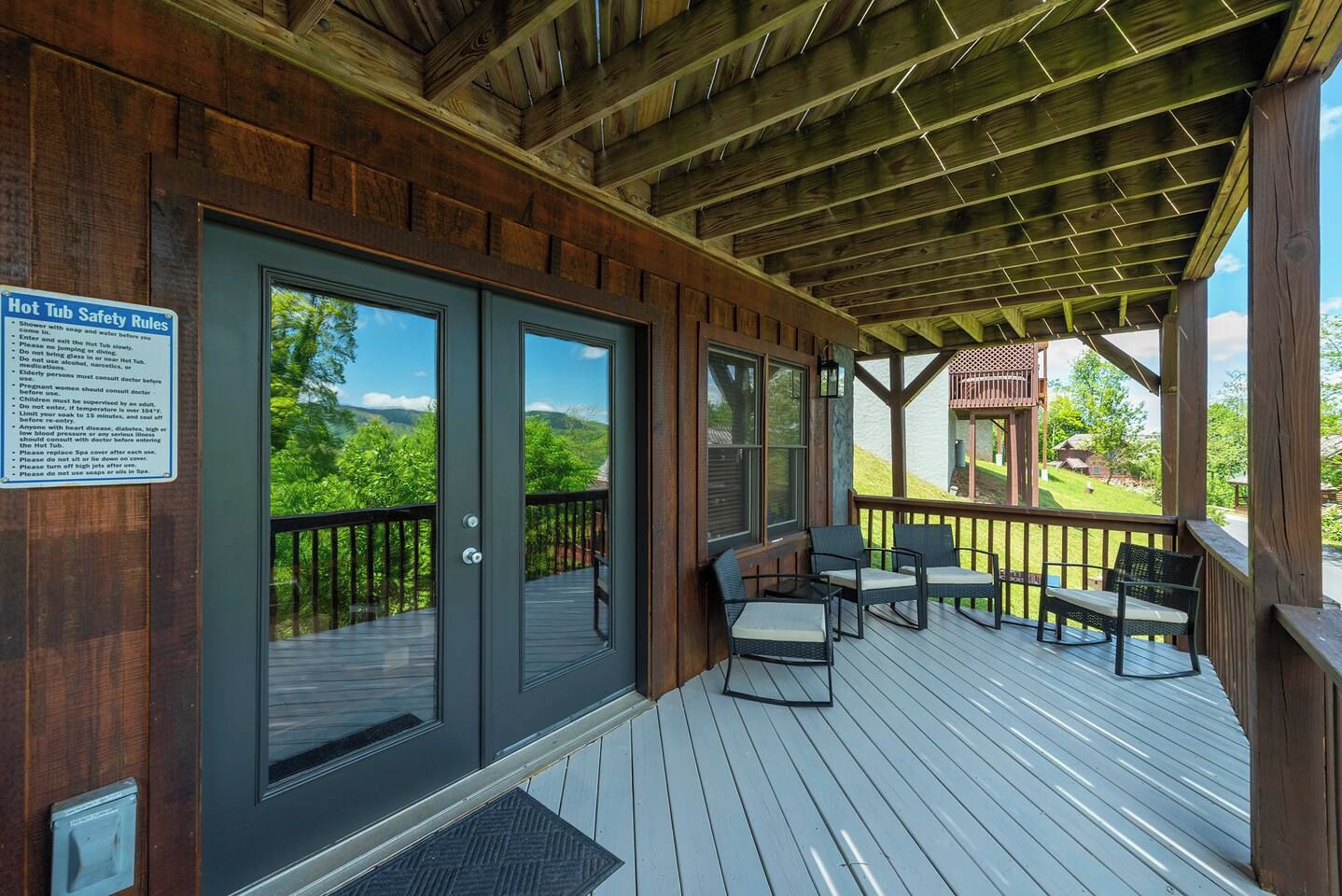 A wooden deck with outdoor seating and a view of the landscape.