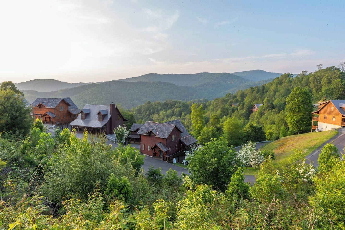 Un ensemble de chalets en bois, avec une chaîne de montagnes en arrière-plan.