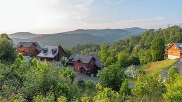 Un ensemble de chalets en bois, avec une chaîne de montagnes en arrière-plan.