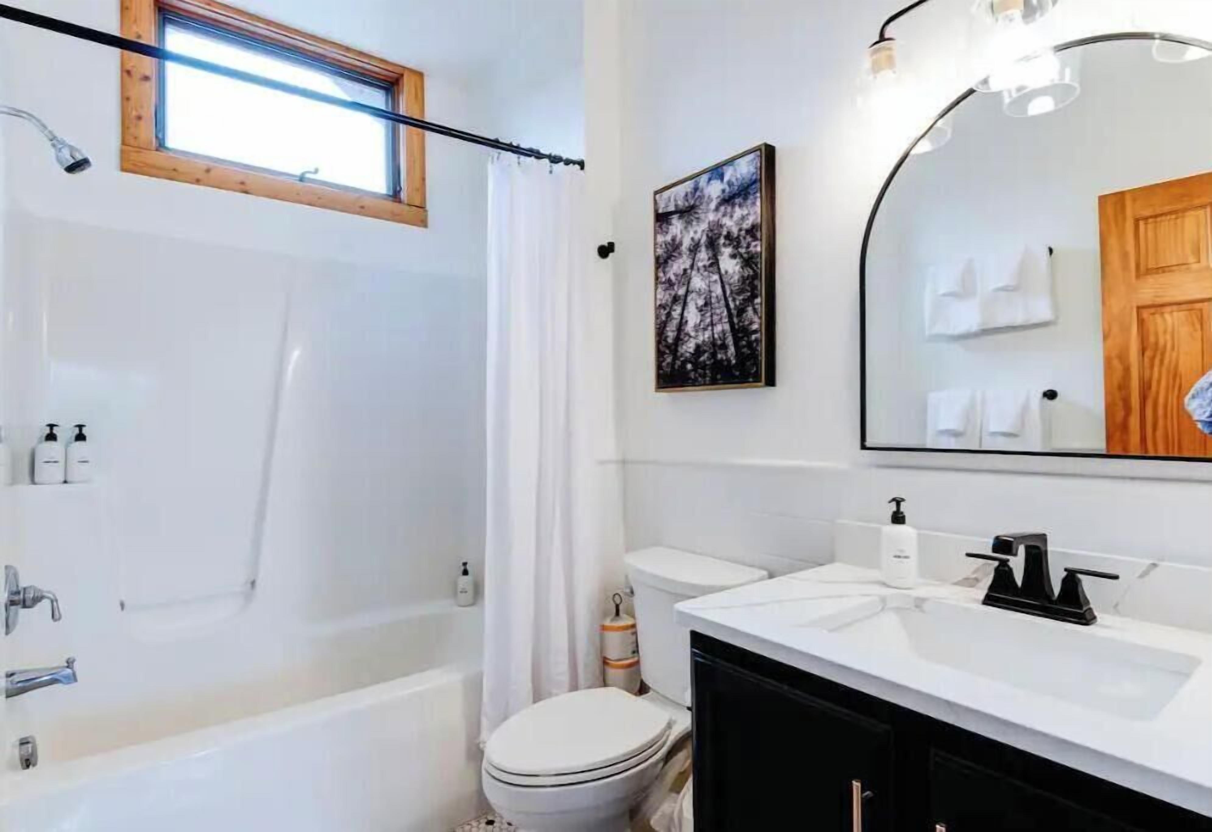 Un baño moderno con bañera, inodoro y lavamanos.