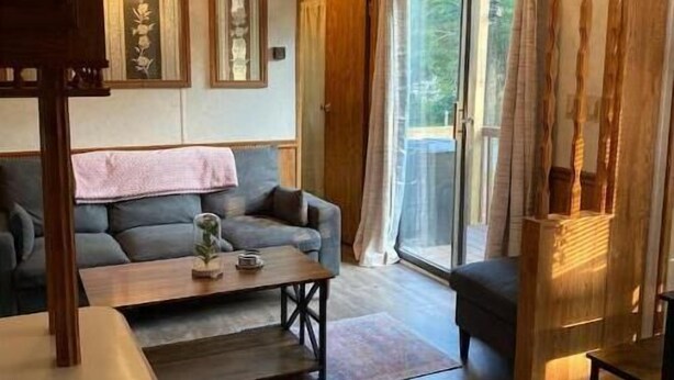 Ein modernes Wohnzimmer mit einer Couch, einem Couchtisch und einem Deckenventilator.