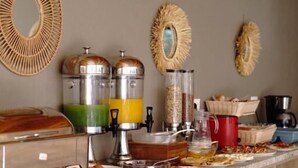 Tarjolla on erilaisia ruokia ja juomia, jotka on asetettu esille buffetpöytään.
