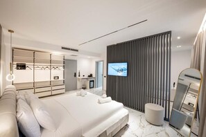 A modern bedroom with a large bed, a TV, a wardrobe, and a mirror. - Resol Hotel 2 (Ksamil)