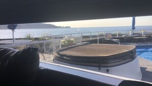 A poolside area with lounge chairs and a view of the sea. - Stunning beach house with pool and hot tub. Pet friendly! Great for families!  (Bellingham)