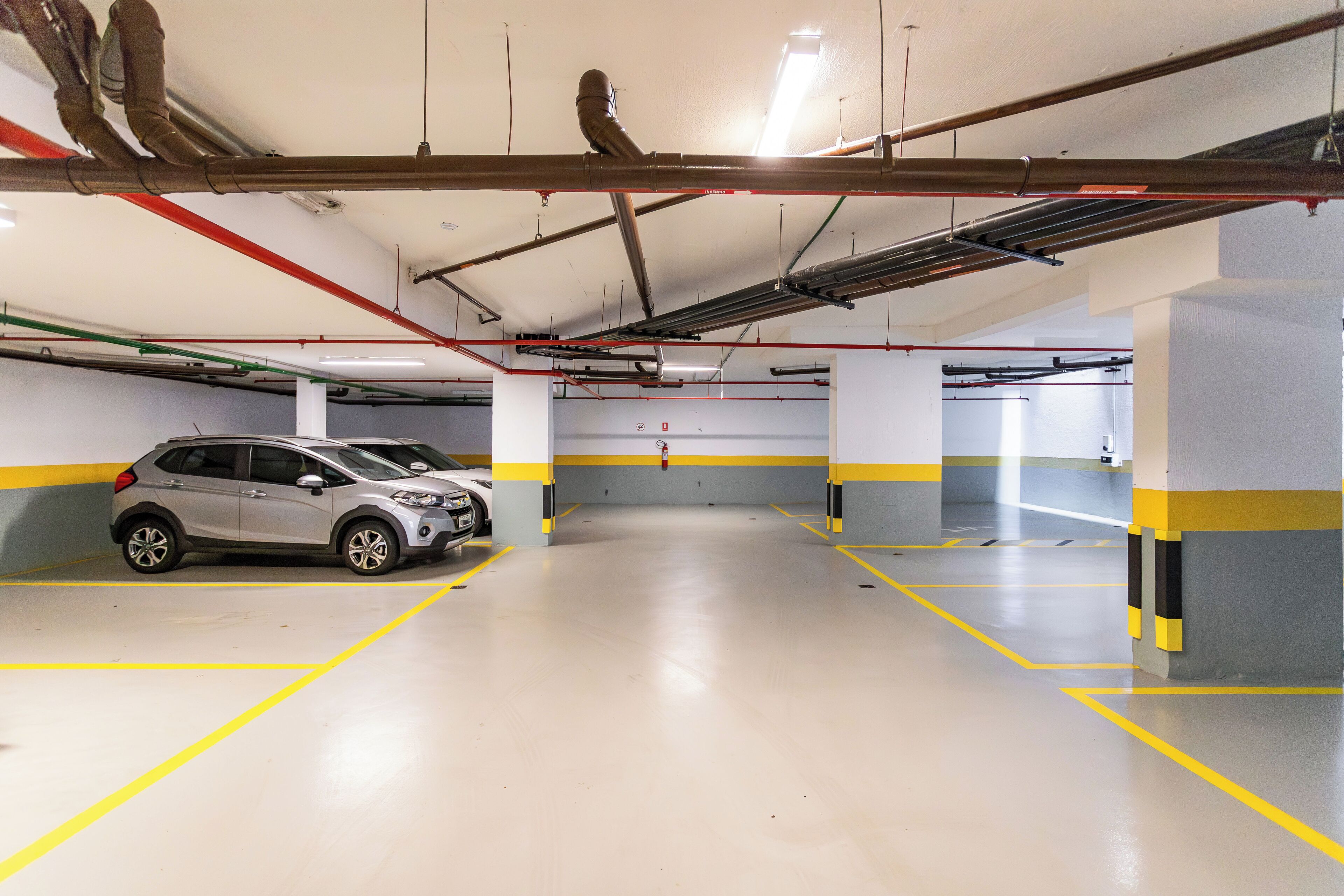 Un parking souterrain où une voiture est garée dans l’une des places disponibles.