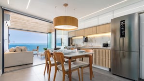 A modern kitchen with a dining area, large windows, and a view of the ocean. - Unhotel (Rio de Janeiro)