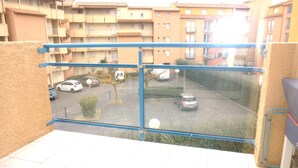 A balcony with a view of a parking lot and buildings. - V0742 - Apt 4 pers Vias Plage parking piscine collective (Vias)