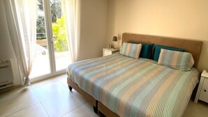 A bedroom with a bed, a nightstand, a lamp, and a ceiling fan.