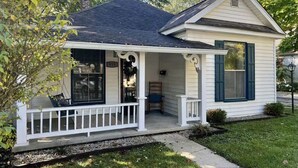 Une petite maison de plain-pied avec un porche, une cheminée et une boîte aux lettres.