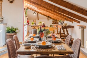 A dining area with a wooden table set for six, surrounded by upholstered chairs. - The Rooftop Penthouse (Lucca)