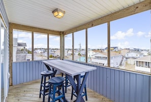 Enjoy an outdoor space with a table and seating for two, offering a view of the surrounding neighborhood.
