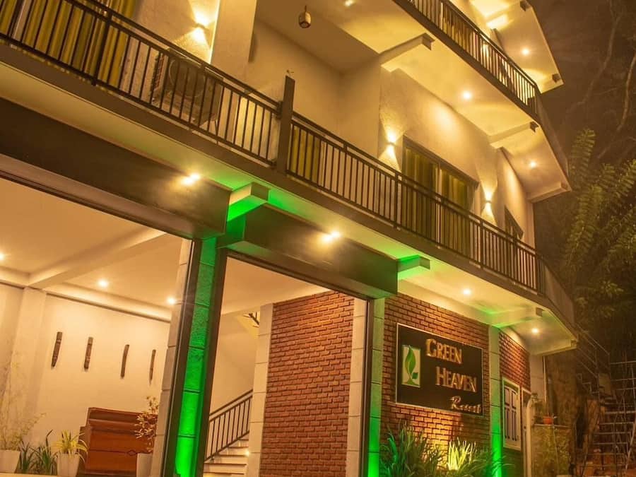 Entrada de un hotel con un letrero que dice "Green Heaven Resort".