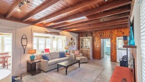 A cozy living room with a wooden ceiling, a sofa, a coffee table, and a fireplace.
