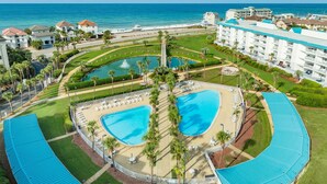A resort with two large swimming pools, a beach area, and a view of the ocean. - Amalfi Coast 209A - Gulf View, Swimming Pool, Tennis Court, Near Shops + Dining! (Miramar Beach)