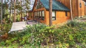 A wooden cabin with a large porch and a covered outdoor seating area. - Game Room | Scenic Views | Cozy Fireplace (Grand Lake)