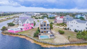 A coastal residential area with houses featuring balconies and a swimming pool. - Pet-friendly canalfront home in Avon w/ private pool and hot tub! (Avon)
