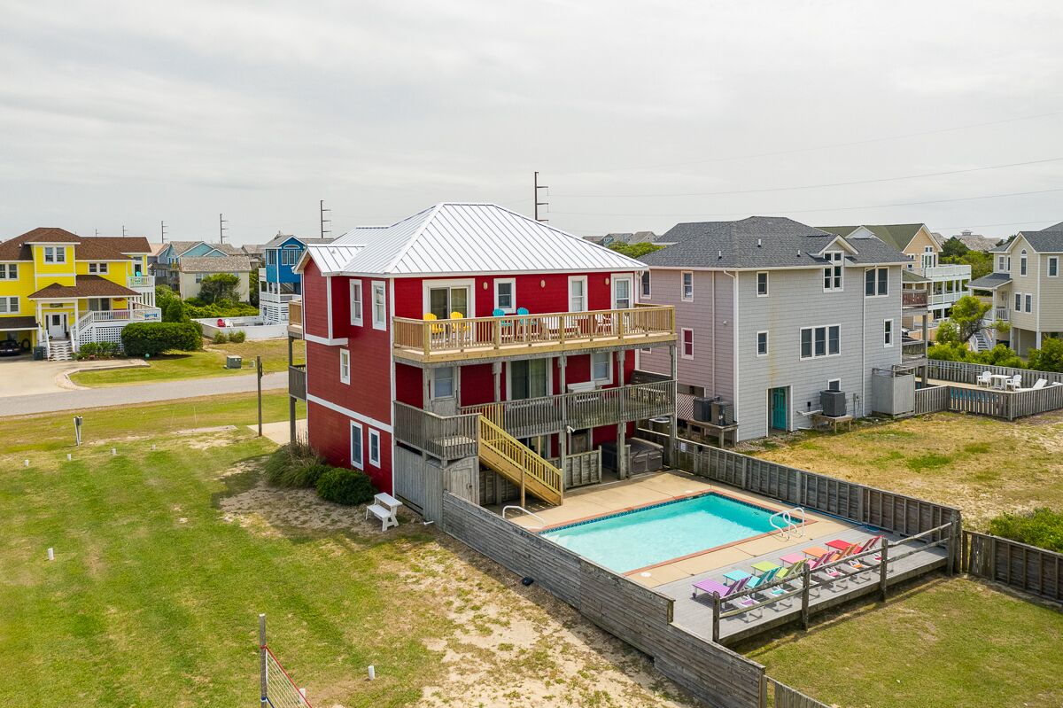 A two-story house with a swimming pool and a deck.