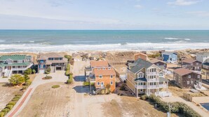 Zona residencial costera con casas, una playa y un cielo despejado.
