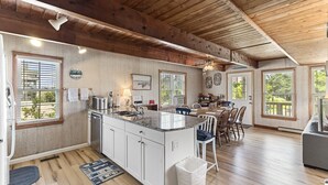 A spacious kitchen with a large island, wooden ceiling, and large windows. - Semi oceanfront home in Salvo w/ beach access just across the street! (Salvo)