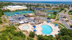 A resort with multiple swimming pools, tennis courts, and a large building likely housing amenities.