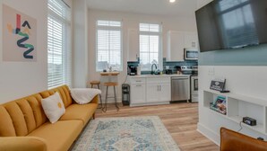 A modern apartment with a living room, kitchen, and dining area.