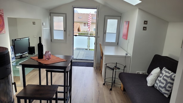 Een ruimtelijk ingedeeld woongedeelte met kitchenette, eethoek en slaapgedeelte.