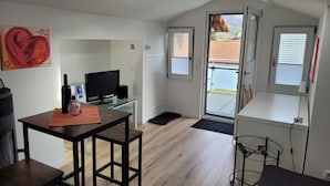 Een moderne woonkamer met een televisie, een fles en een schilderij aan de muur.