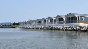 A row of seaside cottages with a stone breakwater in front.