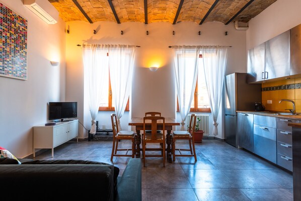 Une cuisine de taille réduite comprenant un coin repas, un téléviseur et un radiateur.