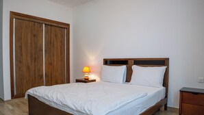 Une chambre à coucher avec un lit en bois, une table de chevet avec une lampe et une armoire.
