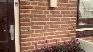 A brick wall with a mailbox and a number sign '26'. - Main Street Beach apartment 150 meters from the beach  (Noordwijk)