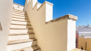 Una escalera blanca con base de piedra que lleva a un edificio.