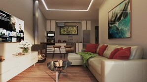 Een moderne woonkamer met een witte bank, een salontafel en een tv waarop een film draait. Ook is er een keuken met een eettafel en stoelen.