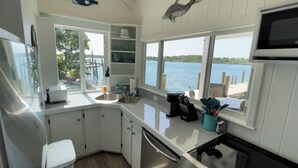A kitchen with a large window, a dishwasher, and a coffee maker.