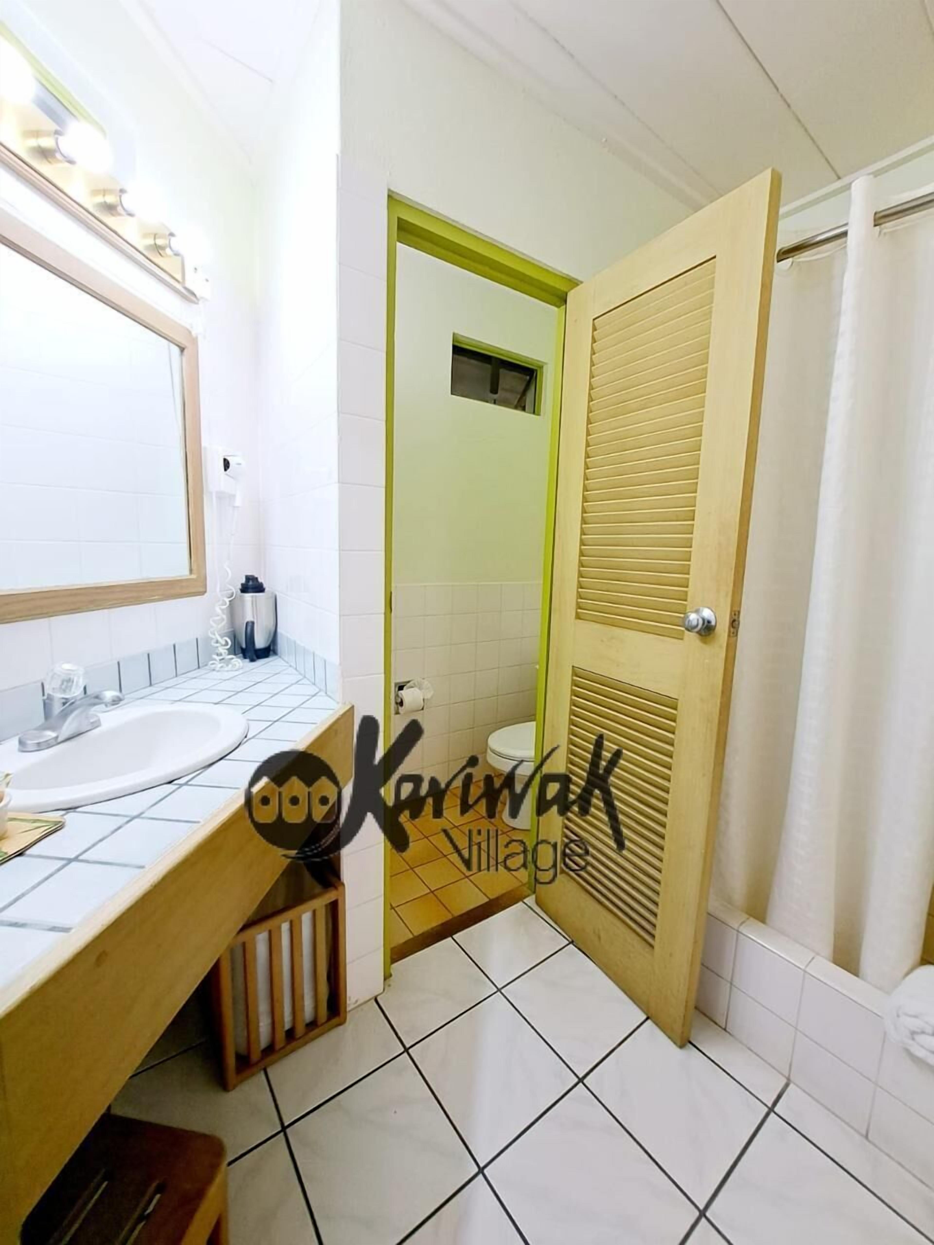 A bathroom with two sinks, a mirror, and a shower area.