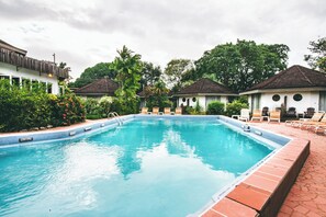 A swimming pool with lounge chairs and a tiled deck. - Kariwak Village Holistic Haven (Crown Point)