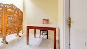 Una habitación con una mesa y una silla de madera, un panel decorativo de madera y una puerta blanca.