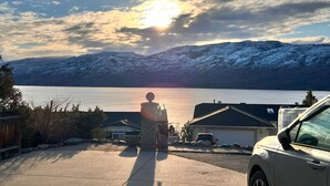 Un quartier résidentiel offrant une vue sur un lac et des montagnes enneigées.