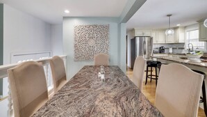 A modern kitchen with a granite countertop, stainless steel appliances, and a decorative wall panel. - Pocono Mountains, Hidden-Gem GameRoom, Firepit, Min to all Attractions (Cresco)