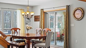 Une salle à manger avec une table en bois, des chaises et un lustre.