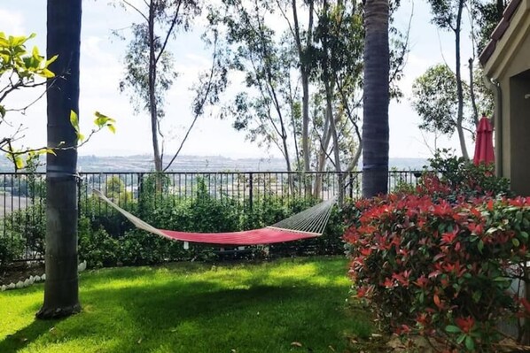 A hammock in a garden with a view of the city.