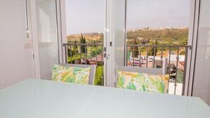 Quarto com vista para uma área residencial, varanda com corrimão e cama com travesseiro.