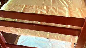 A bunk bed with a wooden frame and a mattress.