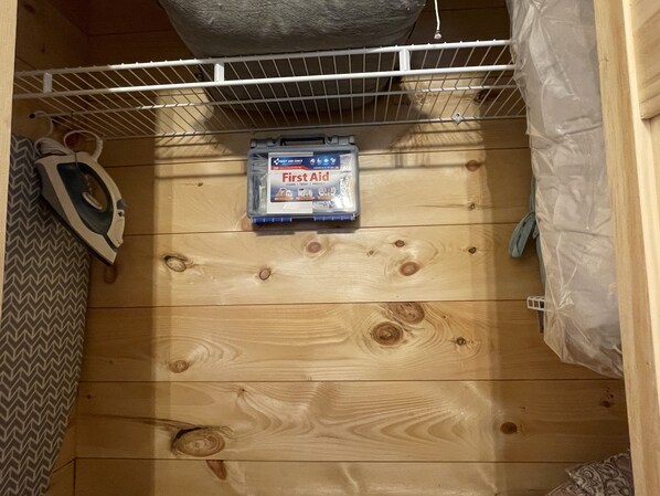 Suelo de madera con un estante blanco que contiene un botiquín.