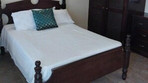 A neatly made bed with a wooden headboard and a nightstand.