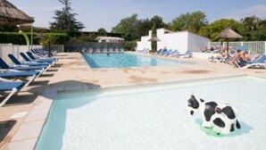 Ein Schwimmbecken mit Liegestühlen und einer Wasserrutsche.