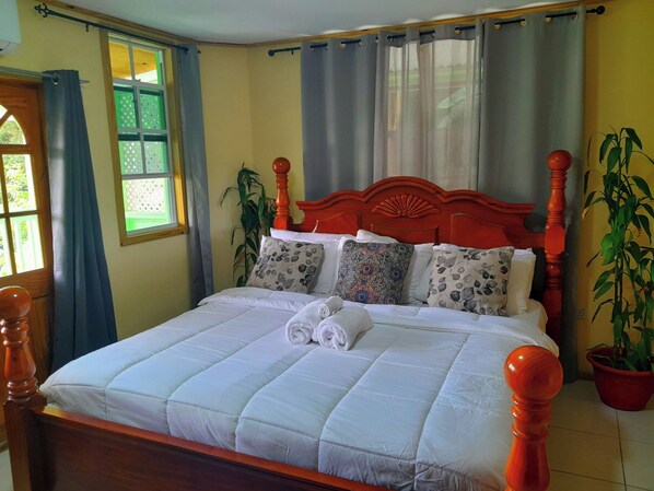 A neatly made bed with a wooden headboard, white bedding, and multiple pillows. - Pinard's Mountain Resort - Cottage 10 (Pointe Michel)